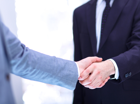 Businessmen shaking hands, isolated on white background.の写真素材