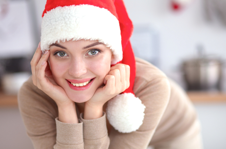 Smiling young woman in the kitchen, isolated on christmasの写真素材