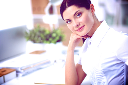 Attractive businesswoman sitting in the office, isolatedの写真素材