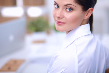 Attractive businesswoman sitting in the office, isolatedの写真素材