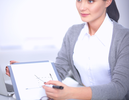 Beautiful businesswoman handing over paperwork extending in officeの写真素材