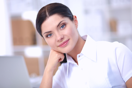 Attractive businesswoman sitting in the office, isolatedの写真素材