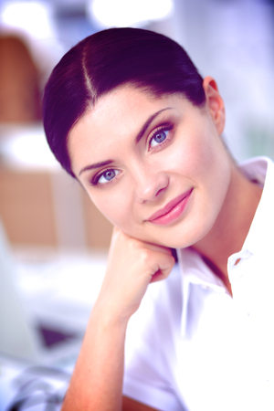 Attractive businesswoman sitting in the office, isolatedの写真素材