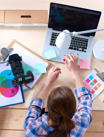 Female photographer sitting on the desk with laptop .の写真素材