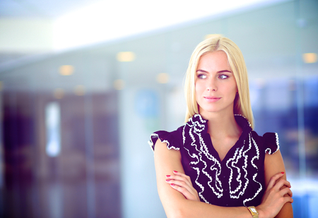 Business woman standing in foreground in office .の写真素材