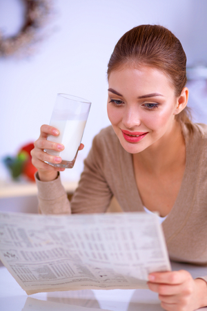 Happy young woman having healthy breakfast in kitchen, isolatedの写真素材
