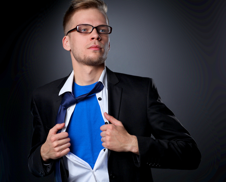 Young businessman acting like a super hero and tearing his shirtの写真素材
