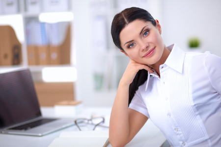 Attractive businesswoman sitting in the office, isolatedの写真素材