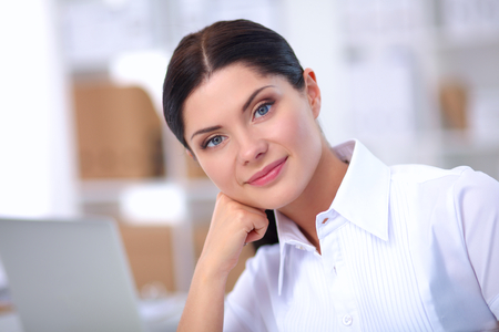 Attractive businesswoman sitting in the office, isolatedの写真素材