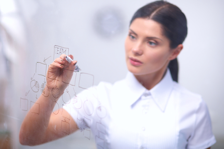Young woman drawing on wihteboard with white copyspace, isolatedの写真素材