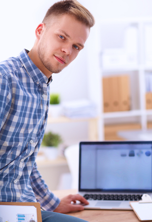 Young businessman working in office, sitting at desk, isolatedの写真素材