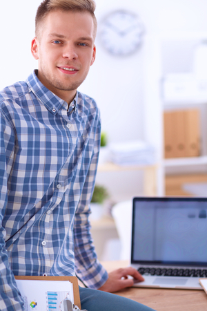 Young businessman working in office, sitting at desk, isolatedの写真素材