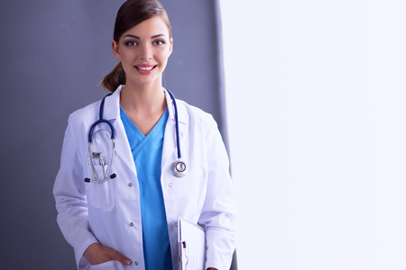 Portrait of young doctor or medic with clipboard and stethoscope isolated onwhit e backgroundの写真素材
