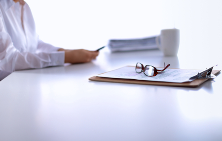 Woman with documents sitting on the desk, in officeの写真素材