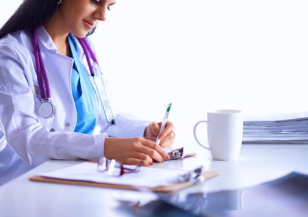 Female doctor sitting on the desk and workingの写真素材