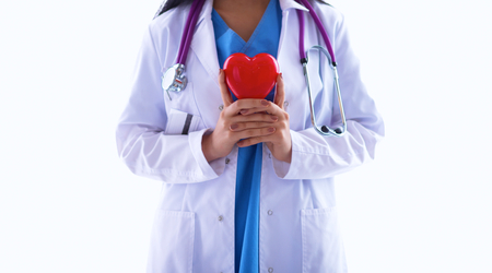 Female doctor with stethoscope holding heart, isolated on white backgroundの写真素材