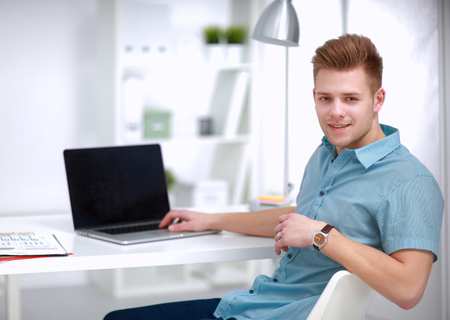 Young businessman working in office, sitting at deskの写真素材