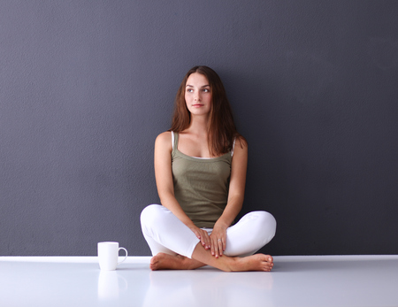 Attractive caucasian girl sitting on floor near wallの写真素材