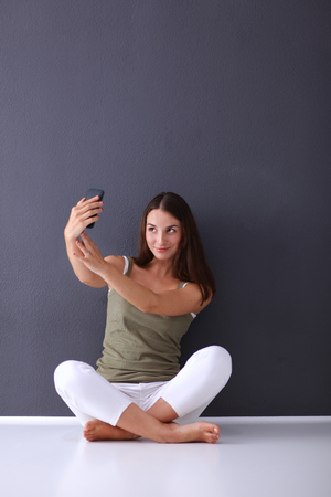 Attractive caucasian girl sitting on floor near wallの写真素材