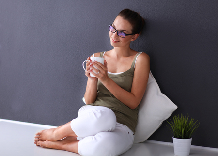 Attractive caucasian girl sitting on floor near wallの写真素材