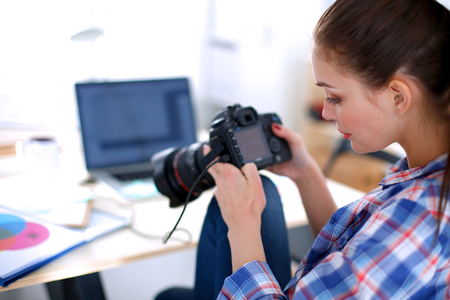 Female photographer sitting on the desk with laptop .の写真素材