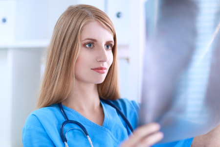 A female doctor showing x-ray at hospitalの写真素材