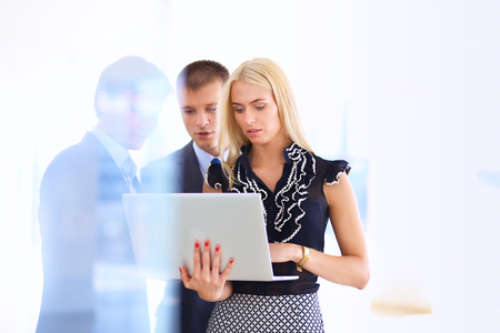 Business woman standing with her staff in background at modern office .の写真素材