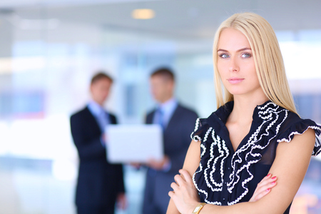 Business woman standing in foreground in office .の写真素材