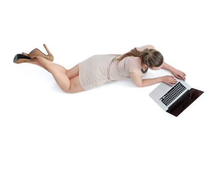 Woman with a laptop lying on the floor  .の写真素材