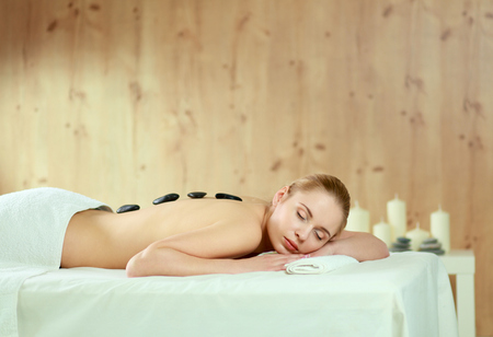Beautiful young woman getting spa massage, lying on salon.の写真素材