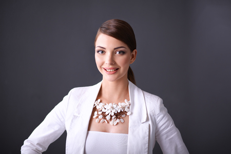 Portrait of pretty young woman with beads, isolated on gray backgroundの写真素材