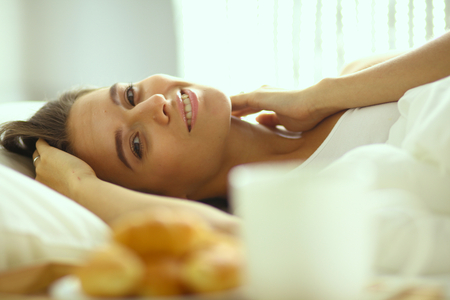 Young beautiful woman lying in bed.の写真素材