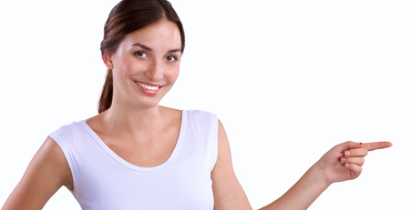 Portrait of a smiling young woman pointing up, isolated on white backgroundの写真素材