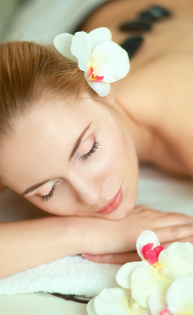 Beautiful young woman getting spa massage, lying on salon.の写真素材
