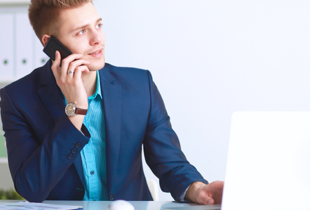 Young businessman working in office, sitting at desk .の写真素材