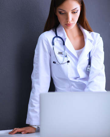 A female doctor working sitting on gray  backgroundの写真素材