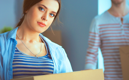 Happy young couple unpacking or packing boxes and moving into a new home.の写真素材