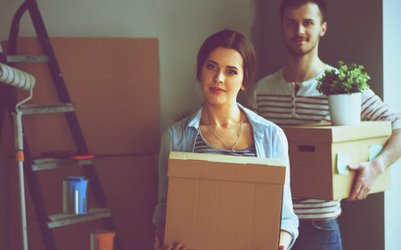 Happy young couple unpacking or packing boxes and moving into a new home.