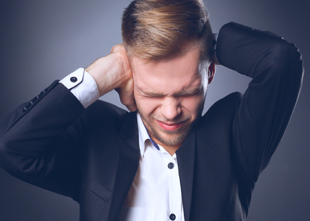 Portrait of young man smiling standing on gray background.の写真素材
