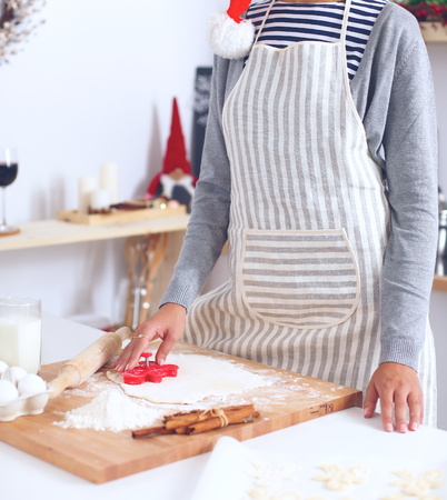 Christmas baking santa woman smiling happy having fun with Christmas preparations wearing Santa hatの写真素材