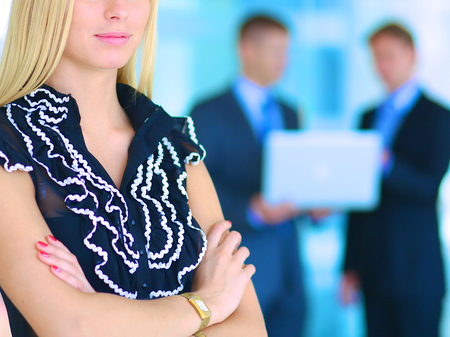 Business woman standing in foreground in office .の写真素材