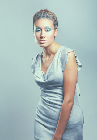 Portrait of a beautiful young woman isolated on gray background.の写真素材