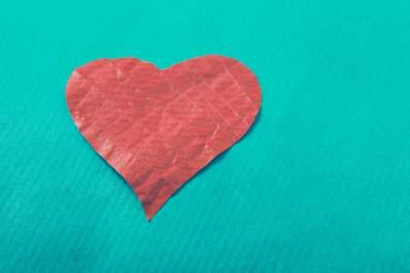Red heart with ribbon, isolated on green background.の写真素材