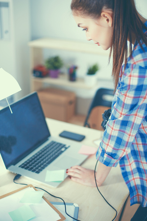 Female photographer sitting on the desk with laptop .の写真素材