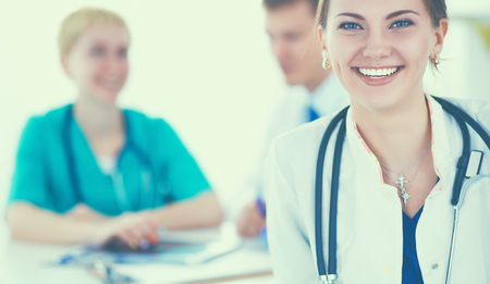 Beautiful young smiling female doctor sitting at the desk.の写真素材