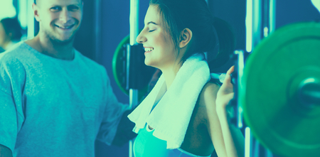 Beautiful woman at the gym exercising with her trainer .の写真素材