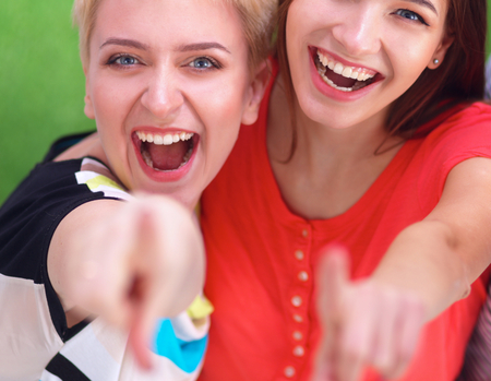 Three happy girls pointing fingers at you choosingの写真素材