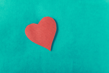 Red heart with ribbon, isolated on green background.の写真素材