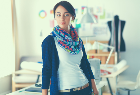 Beautiful young fashion designer standing in studioの写真素材