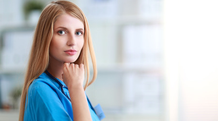 Doctor woman is standing in the near windowの写真素材